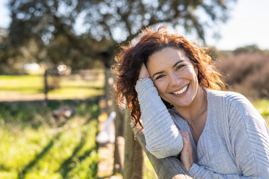 Woman leaning on fence.